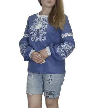 Traditional Ukrainian women's blouse decorated with white blue embroidery on blue homespun fabric